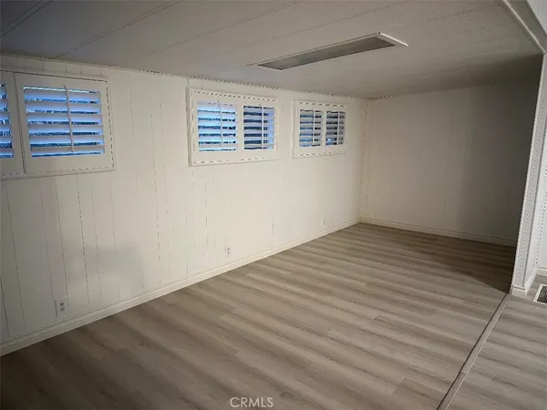 a view of a room with wooden floor and windows
