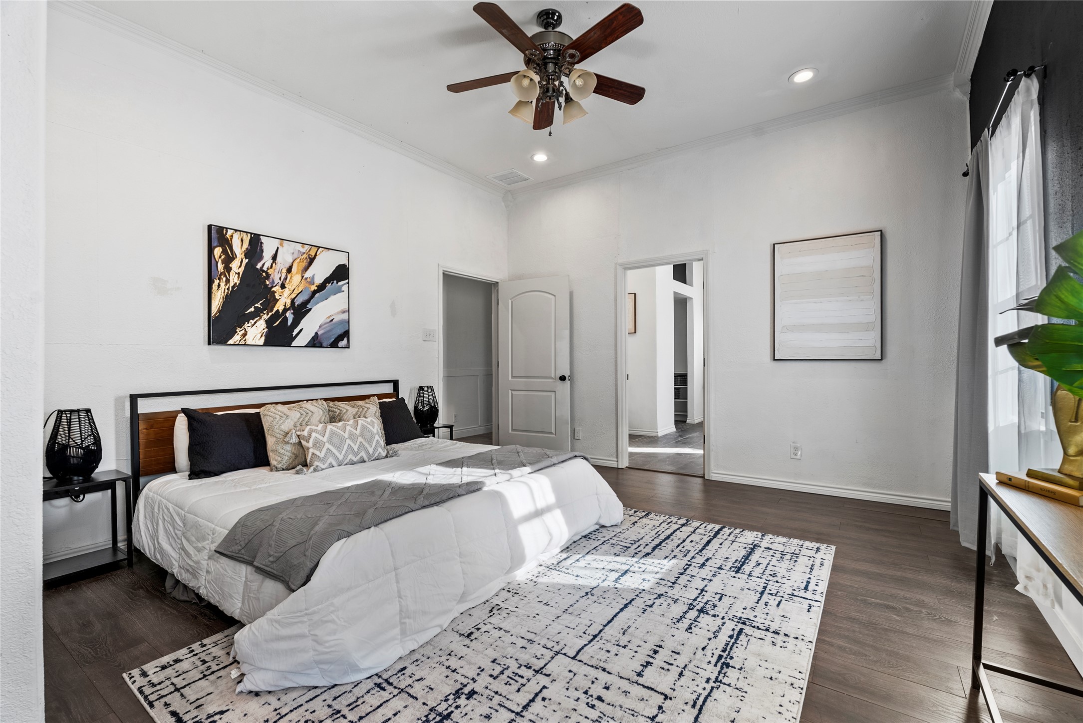 1011 Porter Street Taylor, TX 76574 - Photo 17 of 35 a bedroom with a large bed and a chandelier