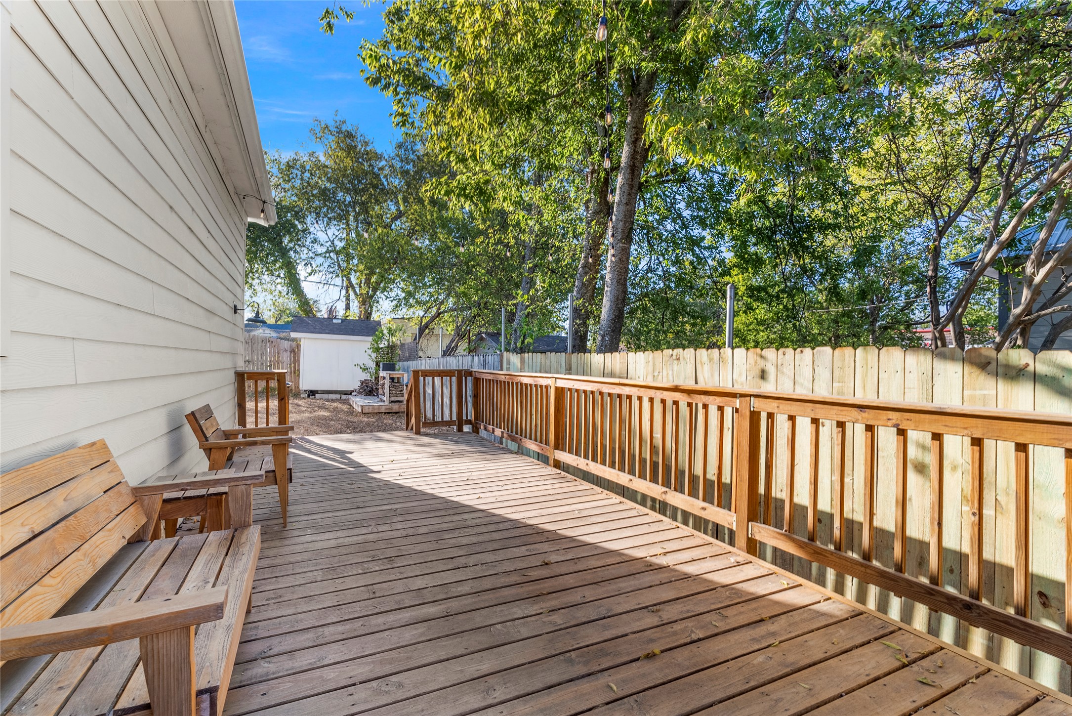 1011 Porter Street Taylor, TX 76574 - Photo 25 of 35 The side deck off the kitchen enjoys shade from both the house and mature trees, and opens to plenty of yard space.