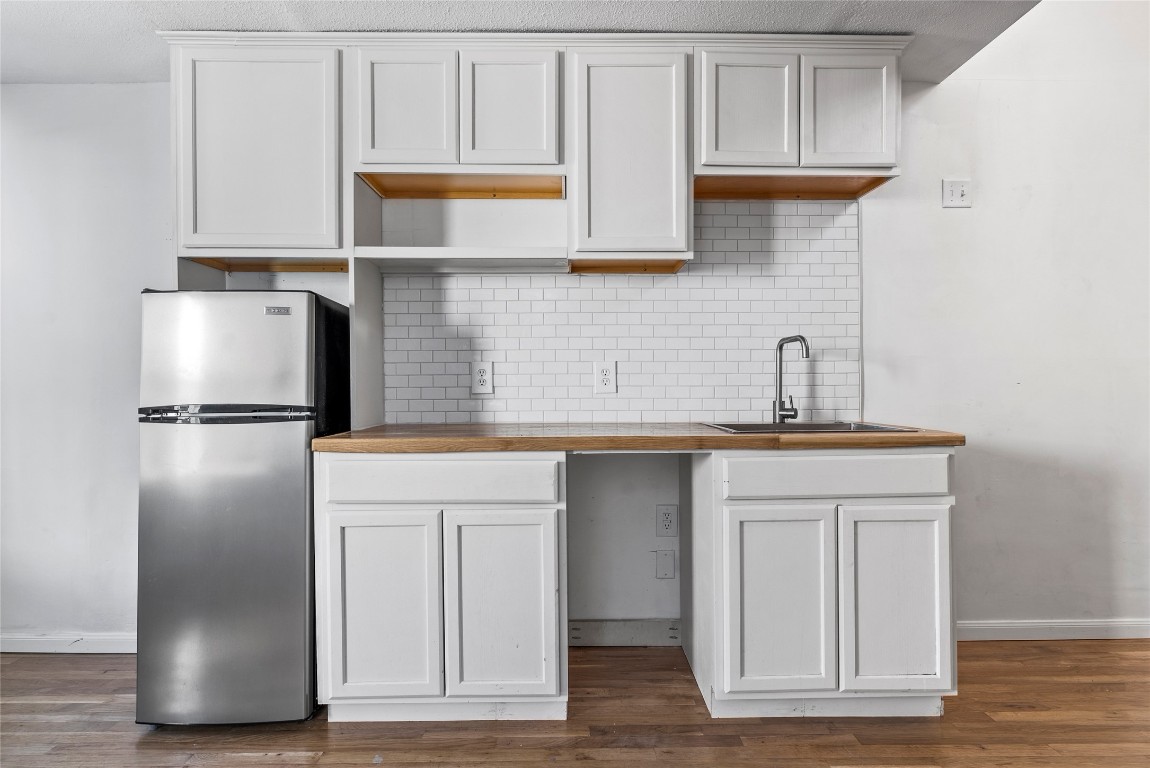 1011 Porter Street Taylor, TX 76574 - Photo 29 of 35 a kitchen with stainless steel appliances granite countertop a refrigerator and a sink