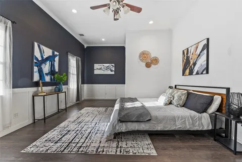 a bedroom with a large bed and a chandelier