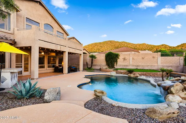 a patio with a table and chairs under an umbrella