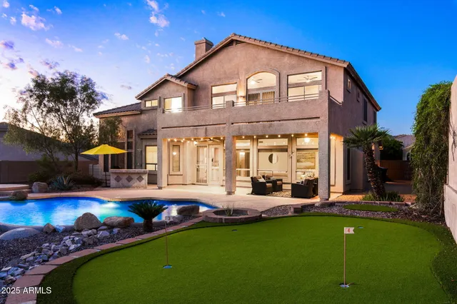 a front view of a house with swimming pool having outdoor seating