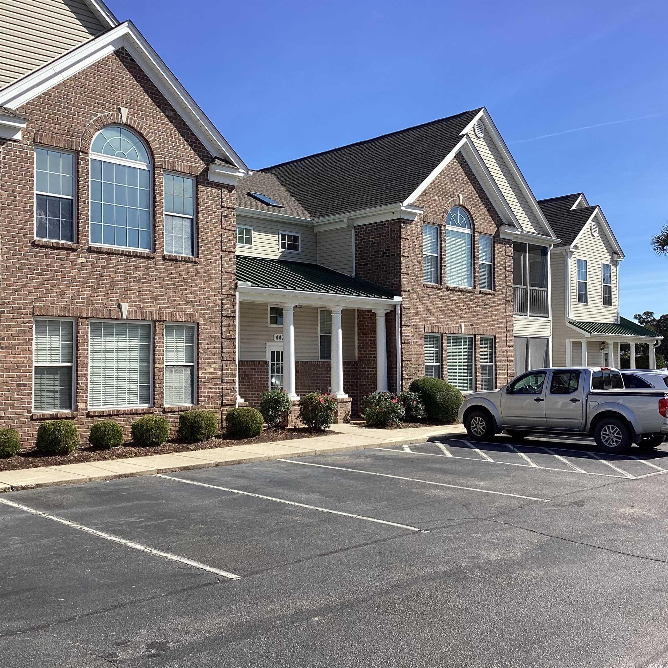 4430 Lady Banks Lane, Unit C1 Murrells Inlet, SC 29576 - Photo 31 of 34 Traditional-style house featuring brick siding, uncovered parking, a standing seam roof, and a metal roof
