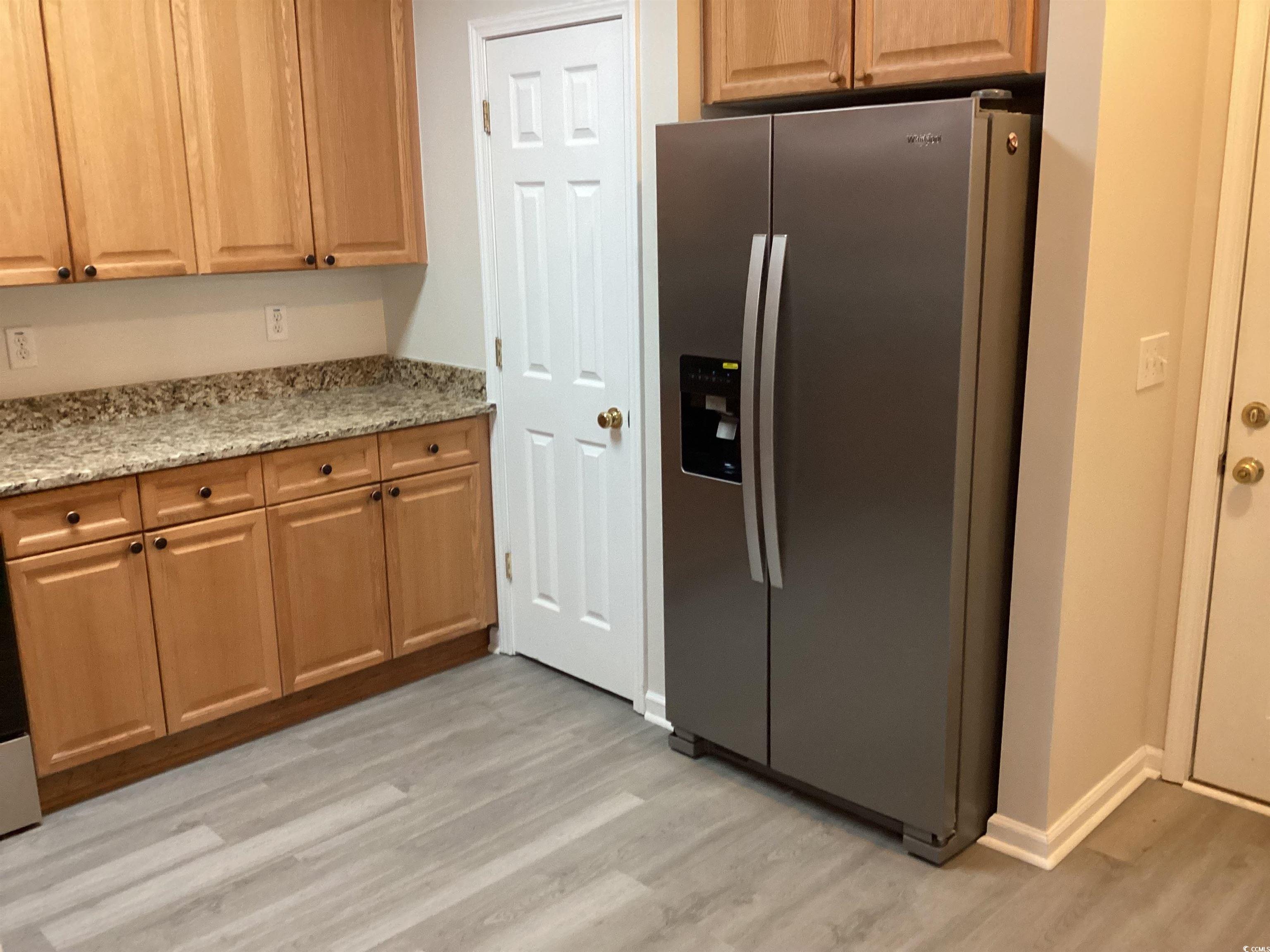 4430 Lady Banks Lane, Unit C1 Murrells Inlet, SC 29576 - Photo 7 of 34 Kitchen with stainless steel fridge, light stone counters, and light wood-style flooring