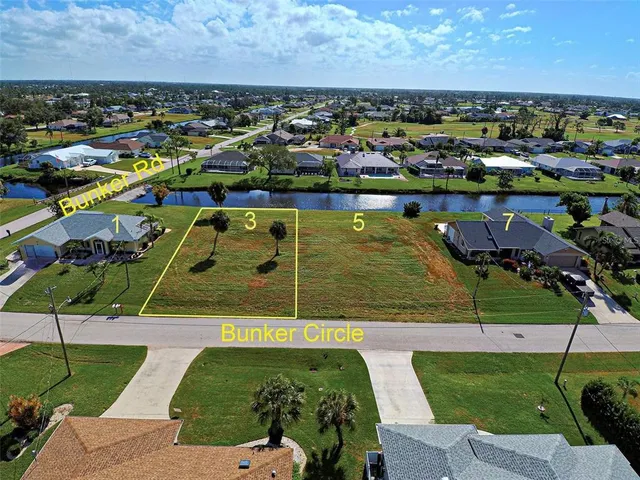 an aerial view of a city with lots of residential buildings and ocean view in back