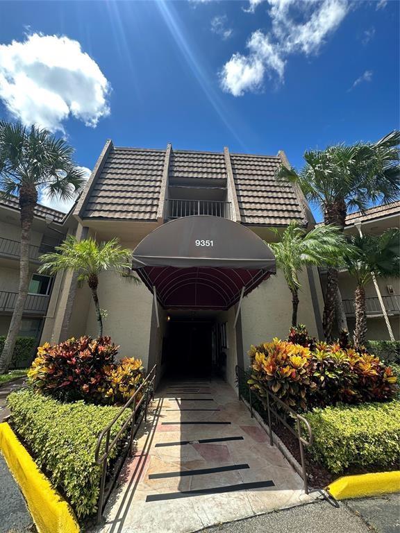 9351 Lime Bay Boulevard, Unit 102 Tamarac, FL 33321 - Photo 2 of 14 a front view of a house with a yard