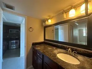 a bathroom with a granite countertop sink and a mirror