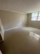 9351 Lime Bay Boulevard, Unit 102 Tamarac, FL 33321 - Photo 9 of 14 an empty room with windows and view of kitchen