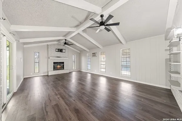a view of empty room with wooden floor and fireplace
