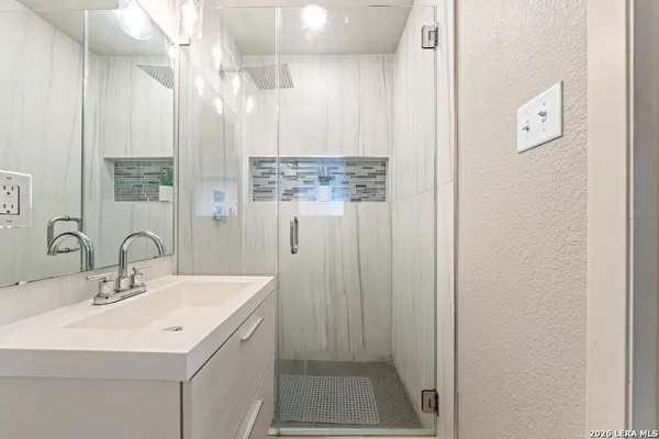 a bathroom with a sink a mirror and a shower