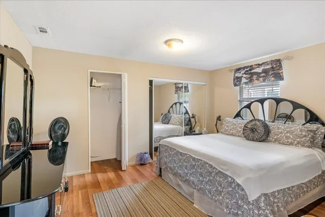 a bedroom with a bed and wooden floor