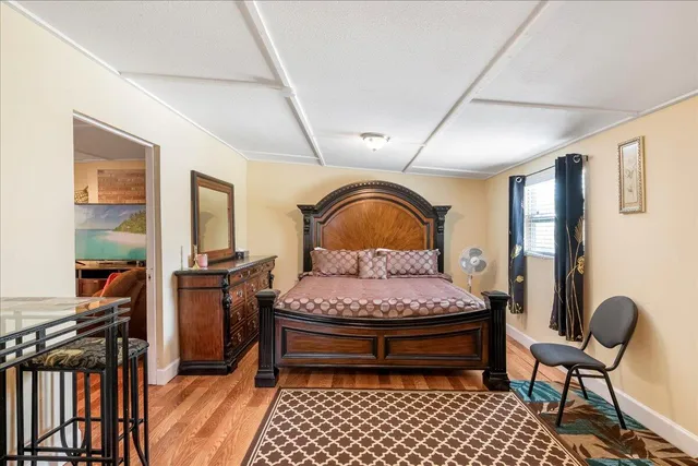 a bedroom with a bed and wooden floor