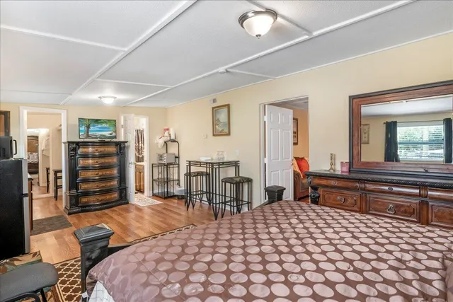 a bedroom with a bed a table and bookshelf