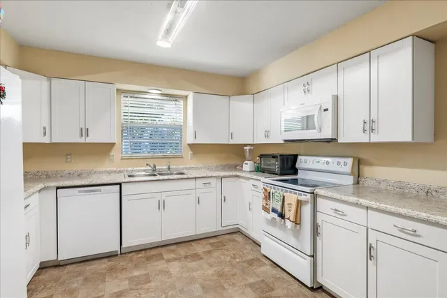 a kitchen with stainless steel appliances granite countertop a sink and cabinets with wooden floors