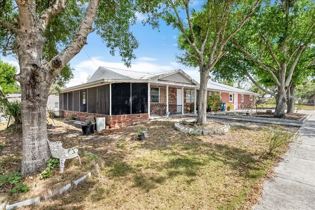 a view of a house with a yard and large tree
