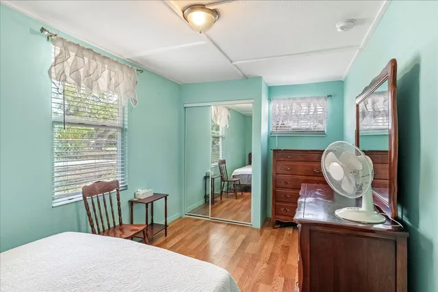 a bedroom with a bed and wooden floor