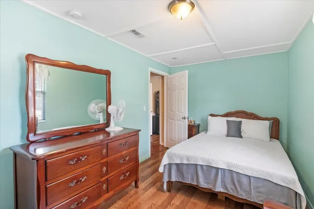 a bedroom with a bed and a mirror on the dresser