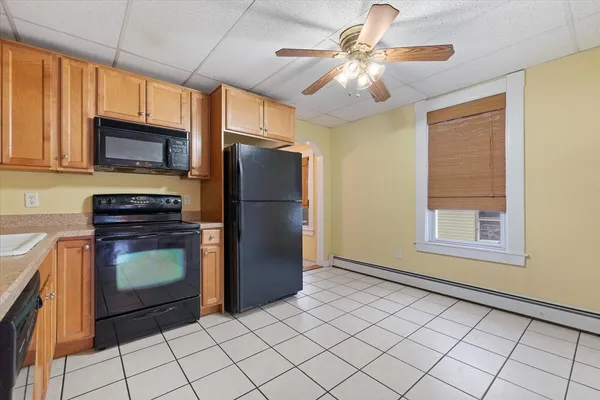 a kitchen with a refrigerator a stove cabinets and a window