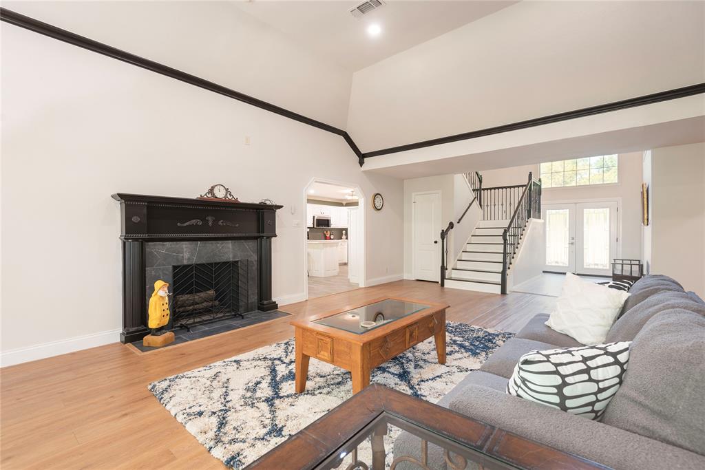 2020 Arbor Bend Road Bonham, TX 75418 - Photo 16 of 40 Living room with wood finished floors, french doors, a tiled fireplace, arched walkways, and lofted ceiling