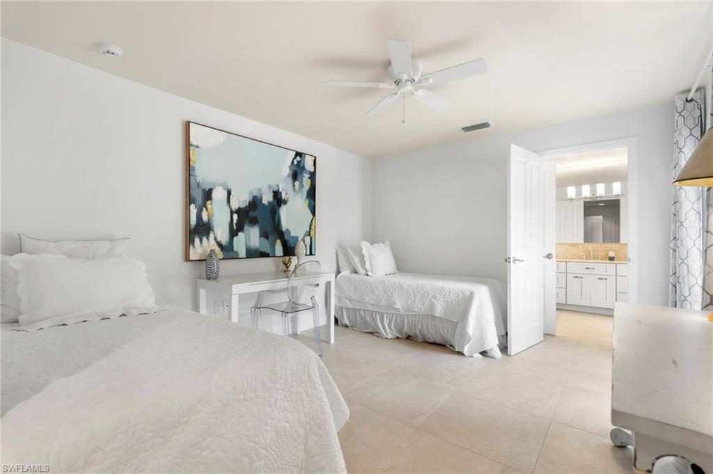 1980 Gordon Drive Naples, FL 34102 - Photo 13 of 14 a bedroom with a large bed and a chandelier