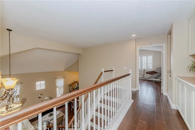 a bedroom with a bed and dresser with wooden floor