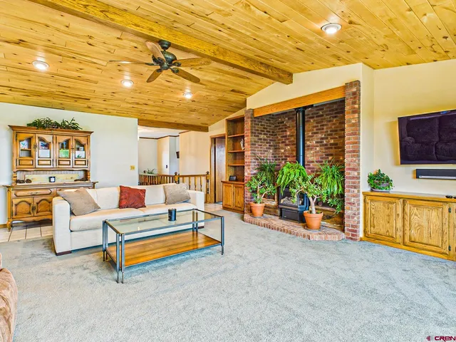 a living room with patio furniture and a flat screen tv