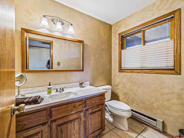 a bathroom with a toilet a sink and mirror