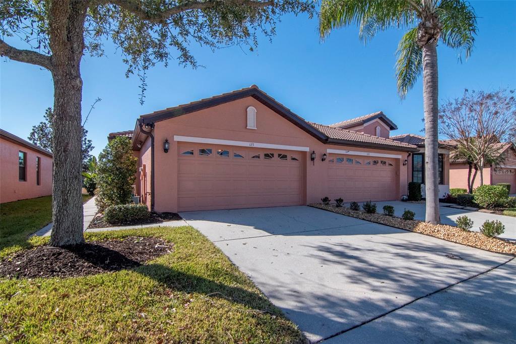 125 Shell Falls Drive Apollo Beach, FL 33572 - Photo 3 of 48 a front view of a house with a yard and garage