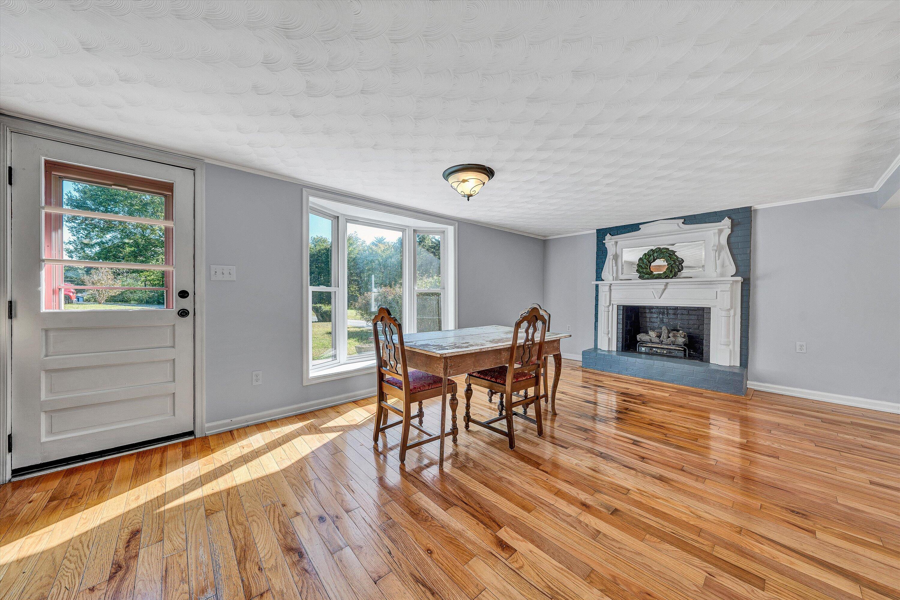 51 Mt Carmel Road Rocky Mount, VA 24151 - Photo 8 of 37 a dining room with furniture a fireplace and wooden floor