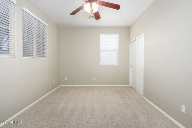 an empty room with windows and cabinet