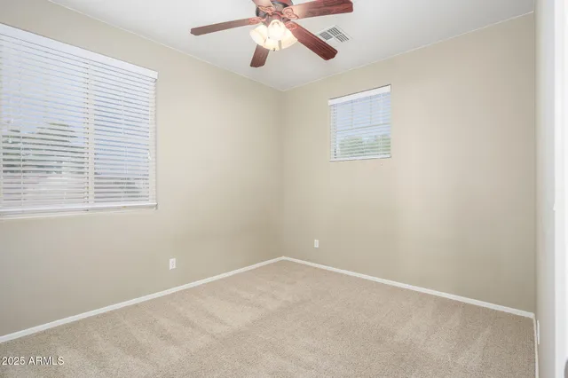 an empty room with a window and a fan