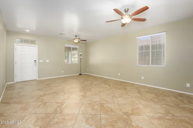 an empty room with a ceiling fan and a window
