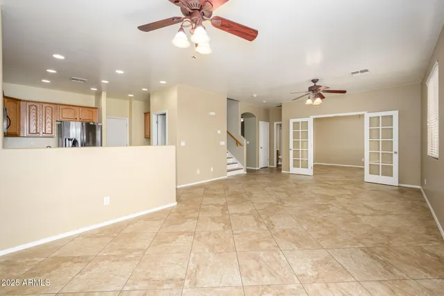 a view of an empty room and kitchen view