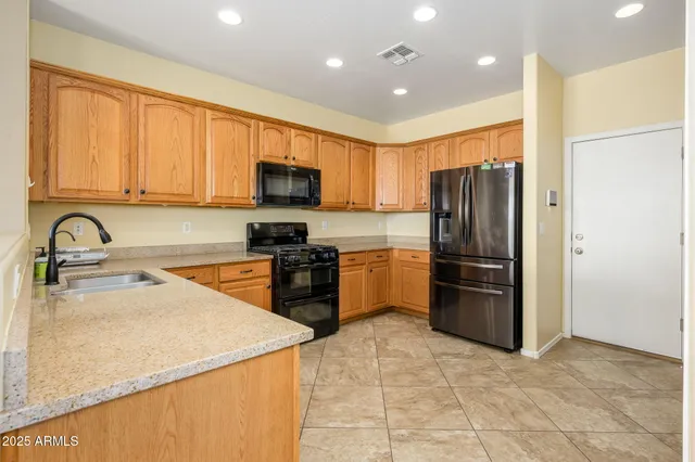 a kitchen with granite countertop a refrigerator and a sink