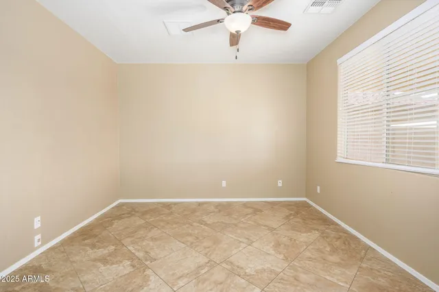 an empty room with a window and a fan