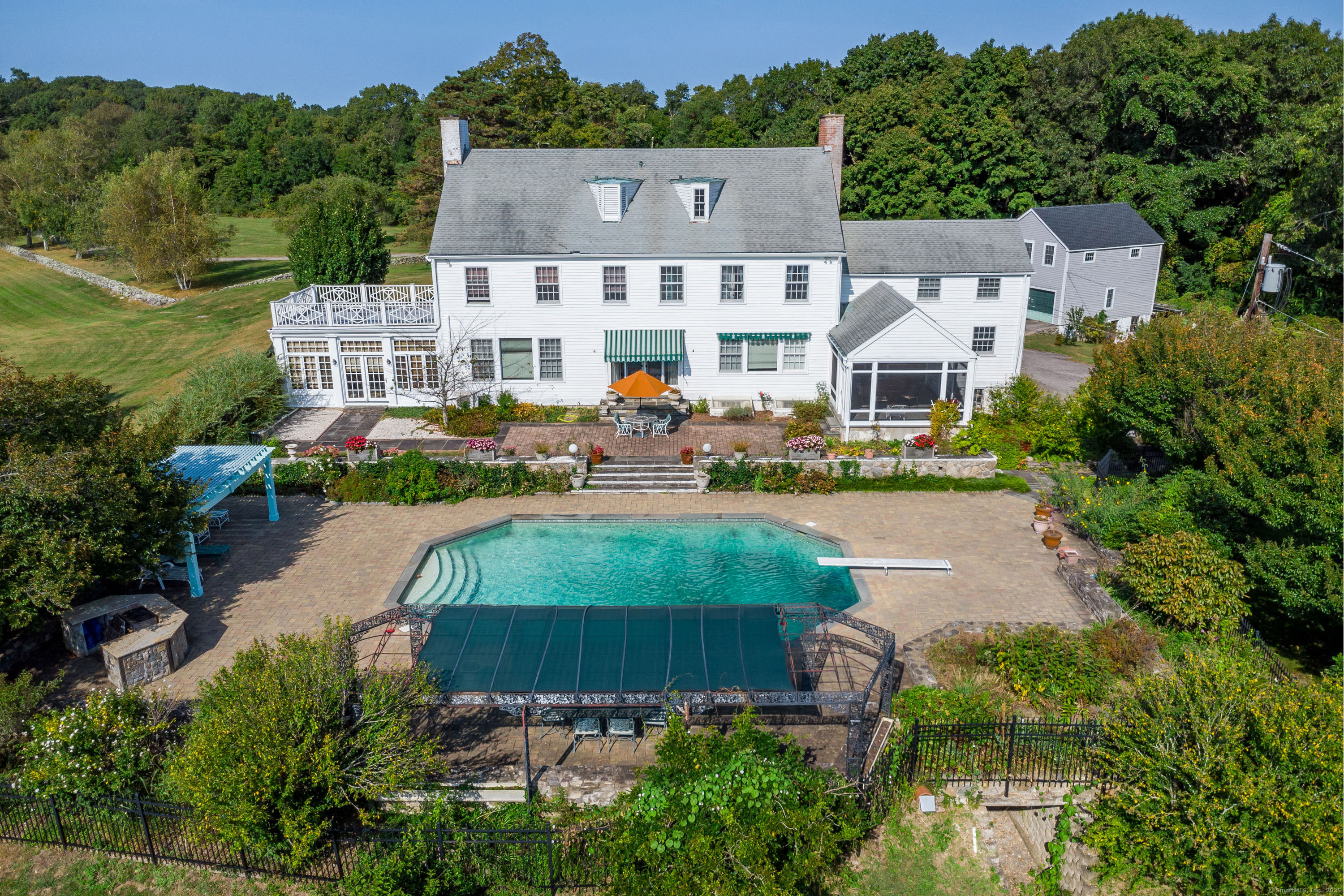 Overhead shot of the pool area. Note the outdoor kitchen, cabana, primary suite rooftop terrace on the left