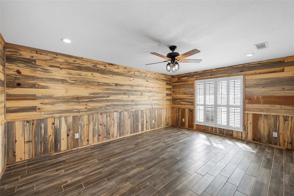 5112 Old Caufield Ranch Road McGregor, TX 76657 - Photo 22 of 38 Spare room featuring a ceiling fan, dark wood-type flooring, recessed lighting, and wooden walls