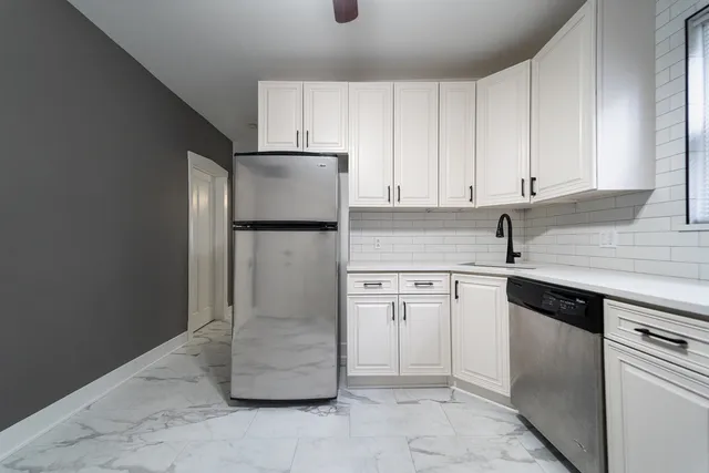 a kitchen with a refrigerator sink and cabinets