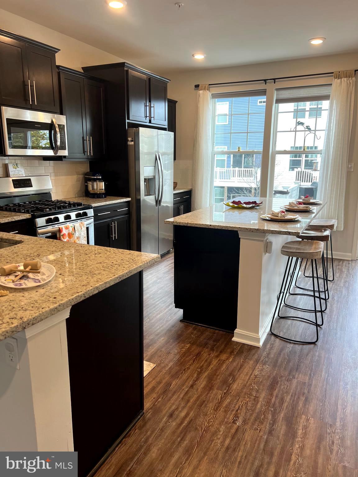 3106 Laurel Hill Road Hanover, MD 21076 - Photo 6 of 25 a kitchen with stainless steel appliances wooden floors and wooden cabinets