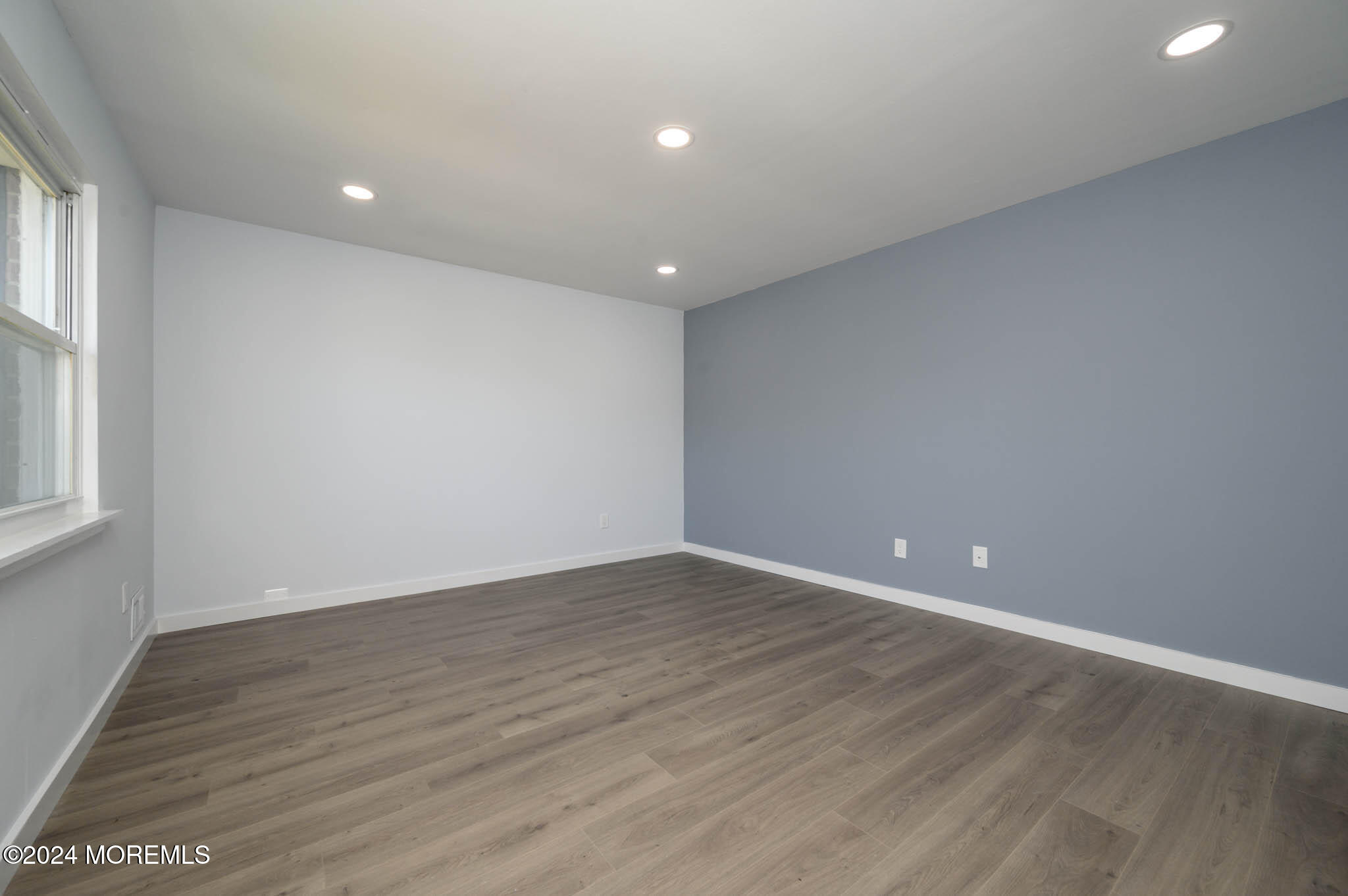 246 Sawmill Road, Unit 403 Brick, NJ 08724 - Photo 18 of 41 a view of an empty room with wooden floor and a window
