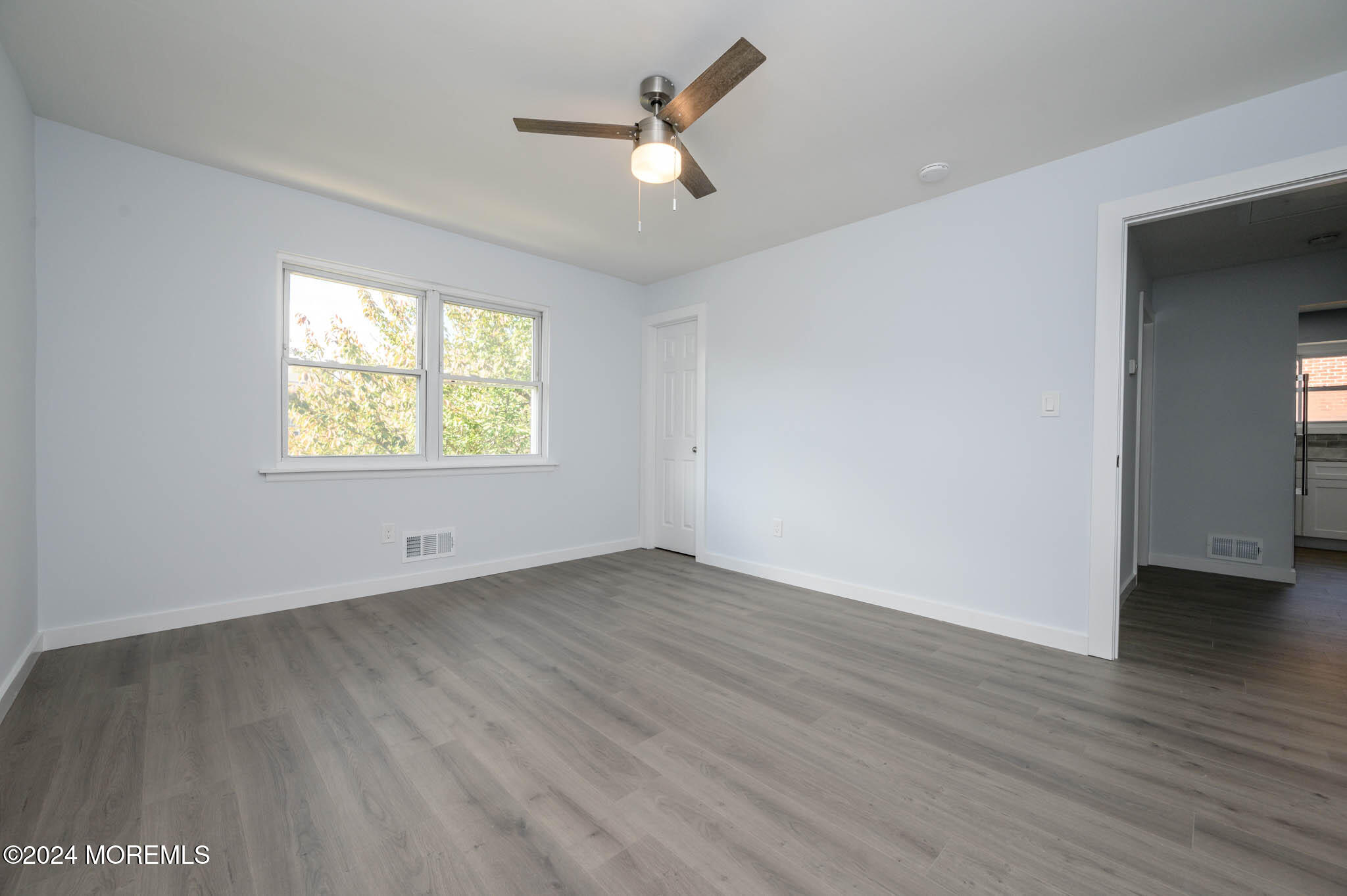 246 Sawmill Road, Unit 403 Brick, NJ 08724 - Photo 25 of 41 an empty room with wooden floor chandelier fan and windows