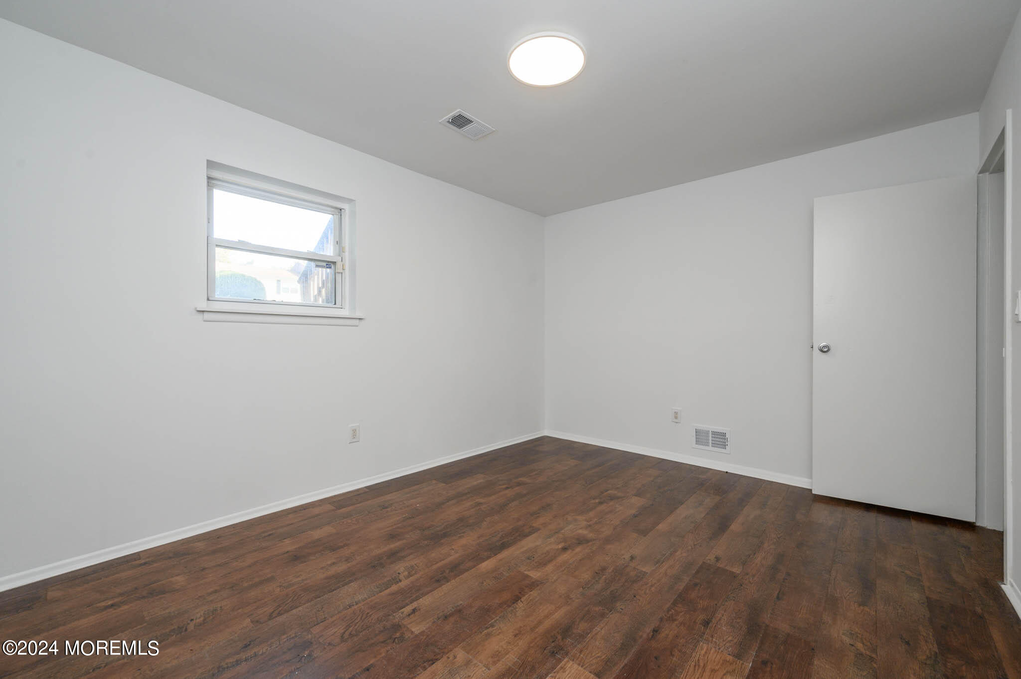 246 Sawmill Road, Unit 403 Brick, NJ 08724 - Photo 36 of 41 an empty room with wooden floor and windows