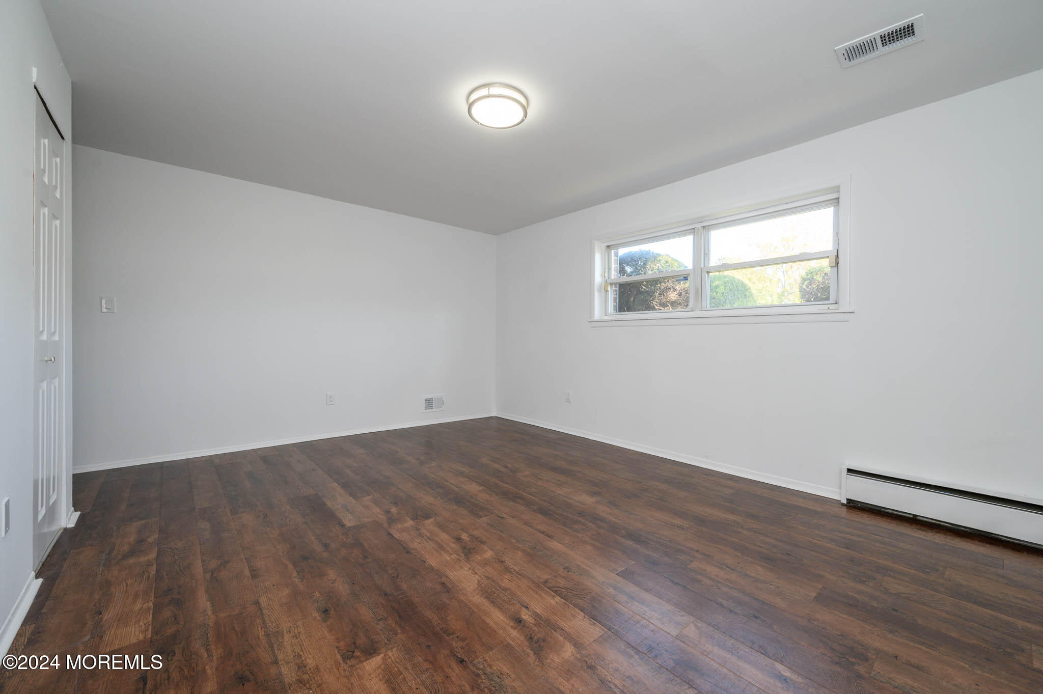 246 Sawmill Road, Unit 403 Brick, NJ 08724 - Photo 39 of 41 an empty room with wooden floor and windows