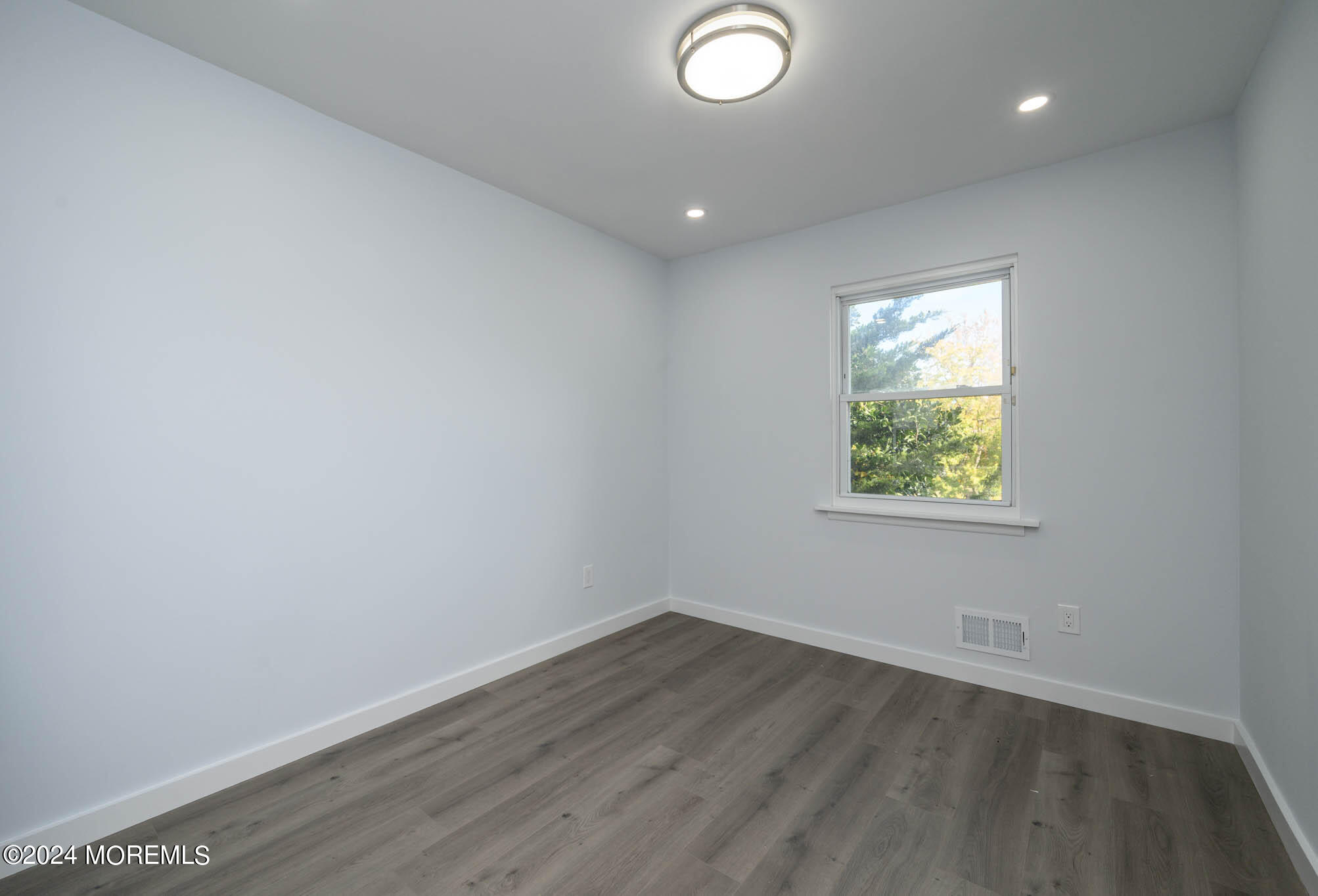 246 Sawmill Road, Unit 403 Brick, NJ 08724 - Photo 8 of 41 an empty room with wooden floor and windows