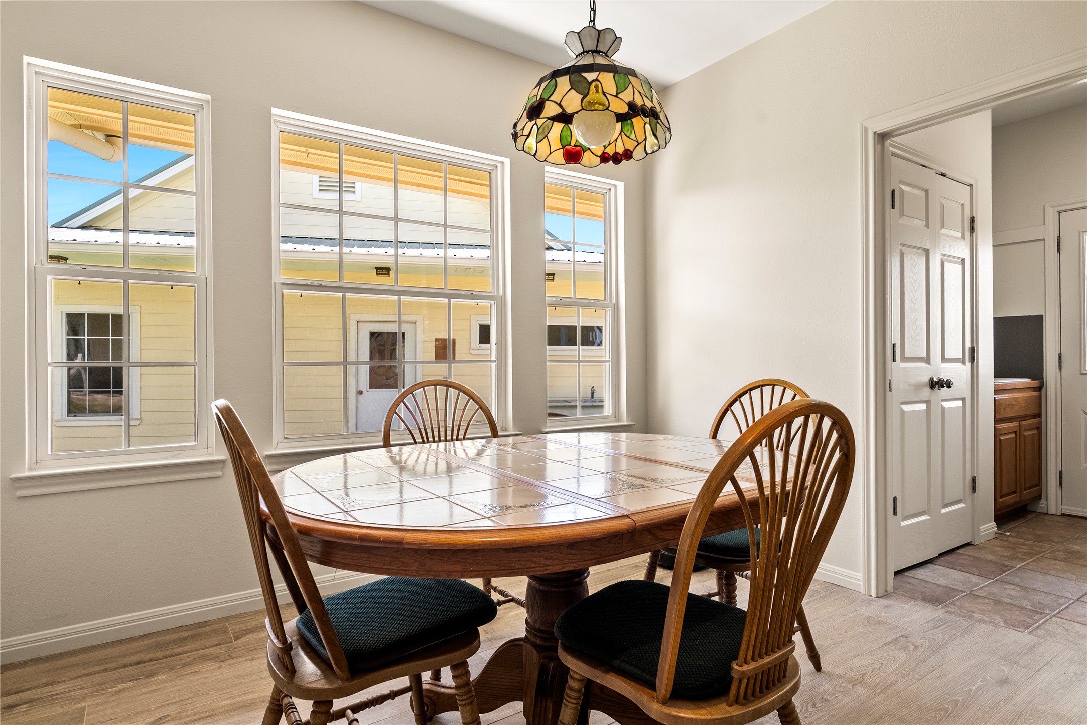 928 Upper Elgin River Road Elgin, TX 78621 - Photo 17 of 40 Dining area with wood-finish flooring, light neutral wall paint, and a decorative stained-glass pendant light fixture.