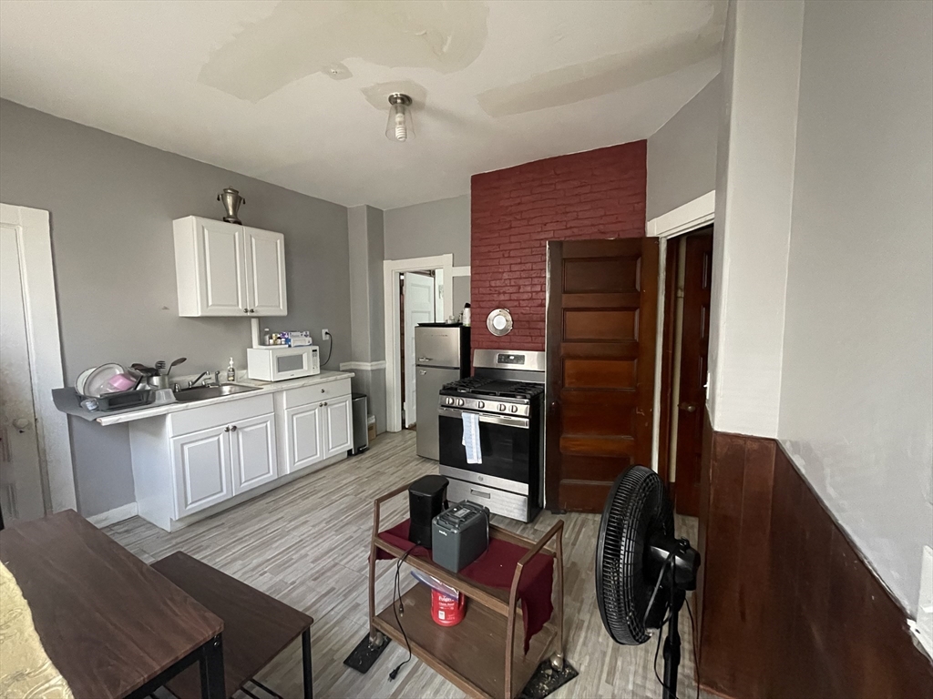 20 Rill Street Boston, MA 02125 - Photo 3 of 20 a kitchen with stainless steel appliances granite countertop a stove refrigerator and a sink