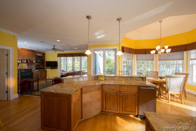 87 Eagle Point Road Lancaster, VA 22503 - Photo 21 of 36 a open kitchen with stainless steel appliances granite countertop a stove top oven a sink dishwasher a dining table and chairs with wooden floor