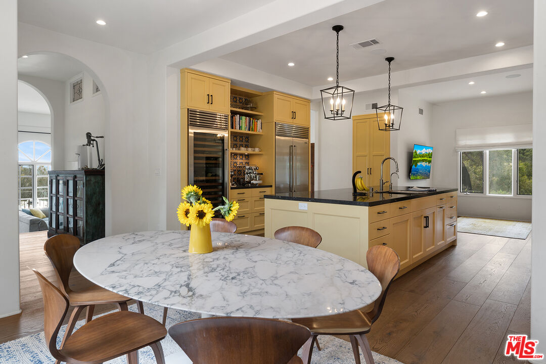 2382 Live Oak Meadows Road Malibu, CA 90265 - Photo 13 of 50 a kitchen with stainless steel appliances kitchen island granite countertop a table chairs and a refrigerator