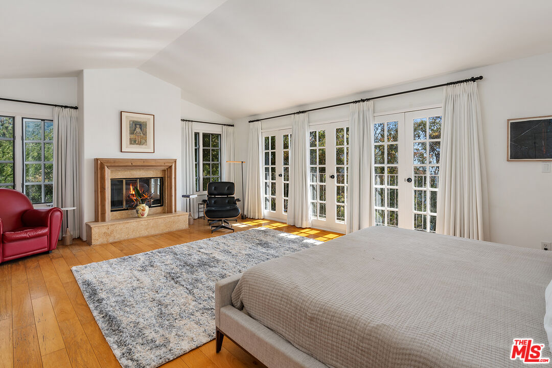 2382 Live Oak Meadows Road Malibu, CA 90265 - Photo 22 of 50 a bedroom with furniture and a fireplace